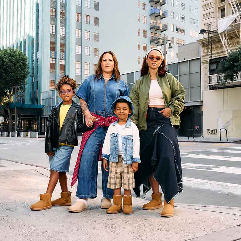 Two adults and two children posing on the street wearing Koola shoes.